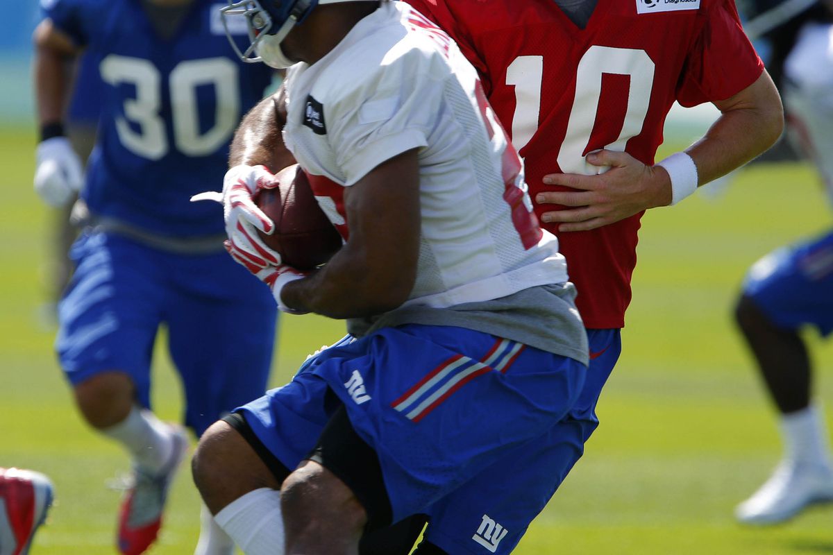 Eli Manning hands to Rashad Jennings during Friday's practice.
