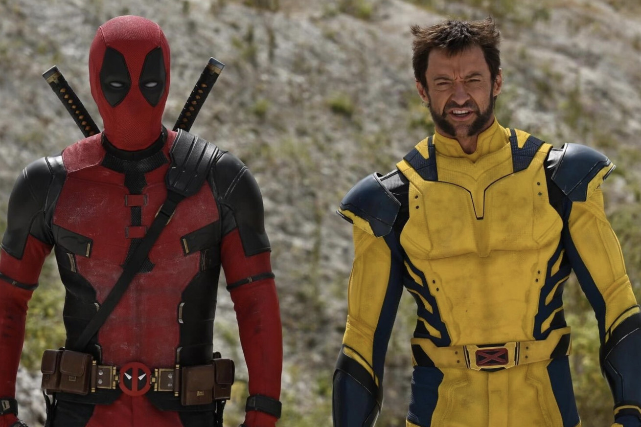 Deadpool on set next to Wolverine in costume.