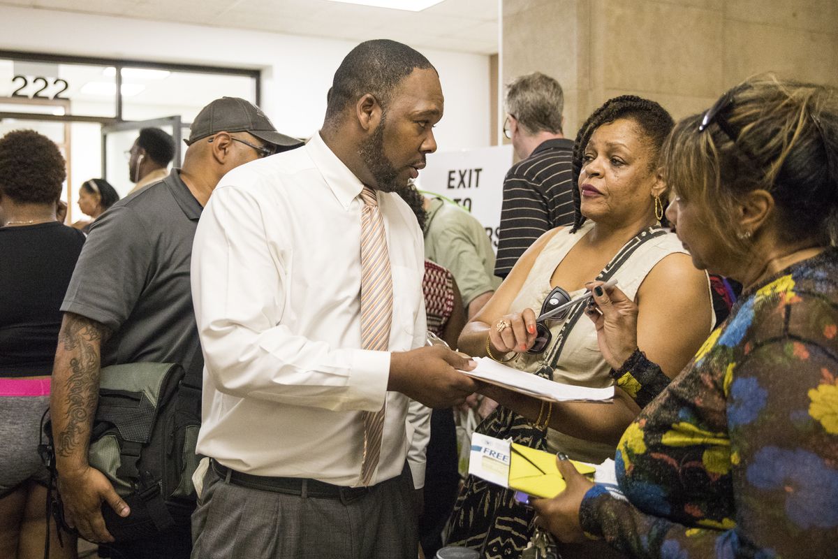 Shawn Childs, with the Willie Wilson Foundation, helps people sign up for up to $500 in Cook County property tax assistance Wednesday morning. | Ashlee Rezin/Sun-Times