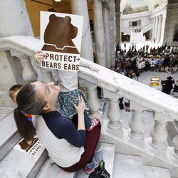 Meagan Colwell holds her niece, who is holding a sign promoting the creation of a Bears Ears National Monument, during a rally at the Capitol in Salt Lake City on Wednesday, May 18, 2016.