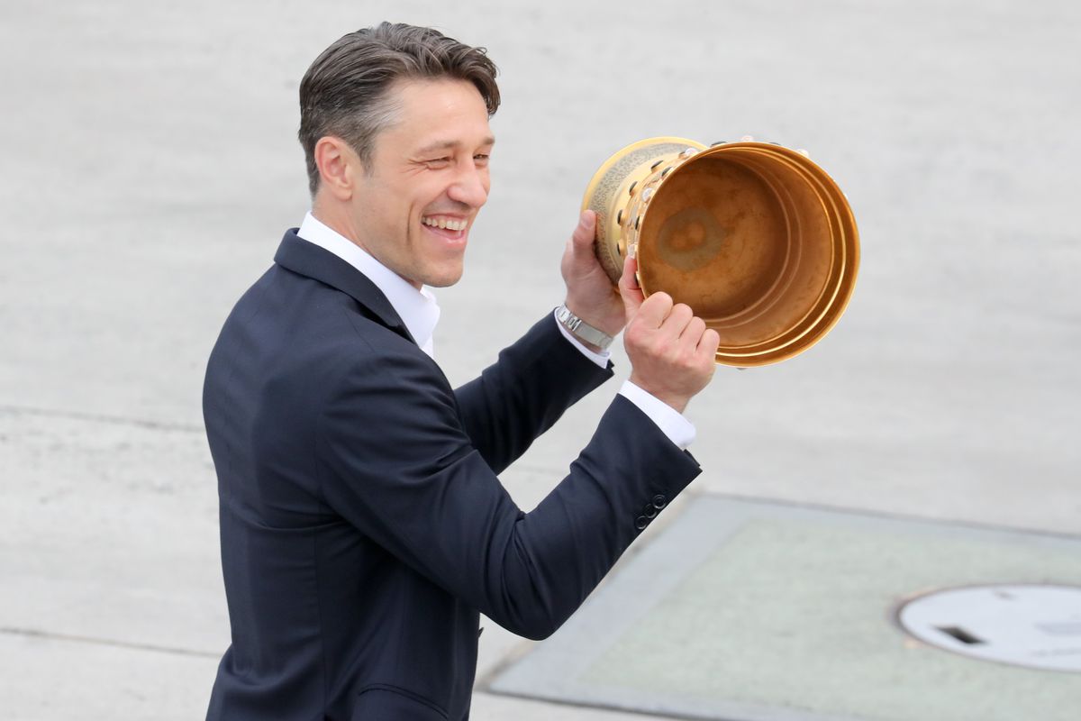 FRANKFURT AM MAIN, GERMANY - MAY 20: Captain Robert Weller presents the DFB Cup trophy as he departs the plane carrying the team of Eintracht Frankfurt during the arrival at Frankfurt International Airport on May 20, 2018 in Frankfurt am Main, Germany.