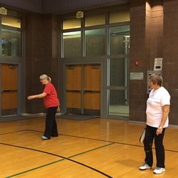 Jeanne Donaldson serves in a game of pickleball in November, while her sister-in-law Kathy Johnson watches.