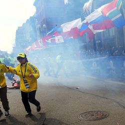 People react to an explosion at the 2013 Boston Marathon in Boston, Monday, April 15, 2013. Two explosions shattered the euphoria of the Boston Marathon finish line on Monday, sending authorities out on the course to carry off the injured while the stragglers were rerouted away from the smoking site of the blasts.