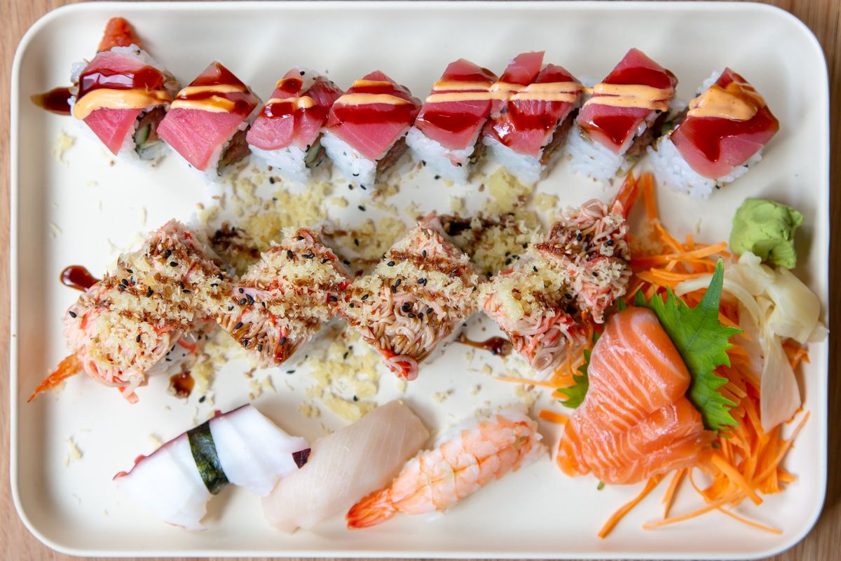 A white tray of sushi and sushi rolls, sashimi, rice