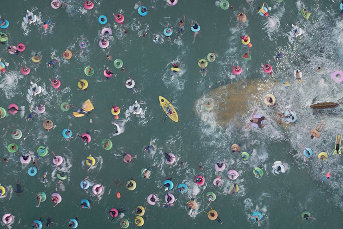 Overhead view of many people in and on floats in water