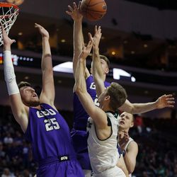 Utah Valley Wolverines guard Conner Toolson has his shot blocked by Joshua Braun of Grand Canyon during the Western Athletic Conference basketball tournament in Las Vegas on Friday, March 9, 2018. At left is Alessanro Lever of Grand Canyon.