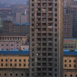 An apartment block stands among the buildings in central Pyongyang, North Korea at dusk on Wednesday, April 10, 2013. 
