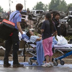 A Moore Medical Center patient sits in the parking lot after a tornado damaged the hospital in Moore, Okla. on Monday, May 20, 2013. 