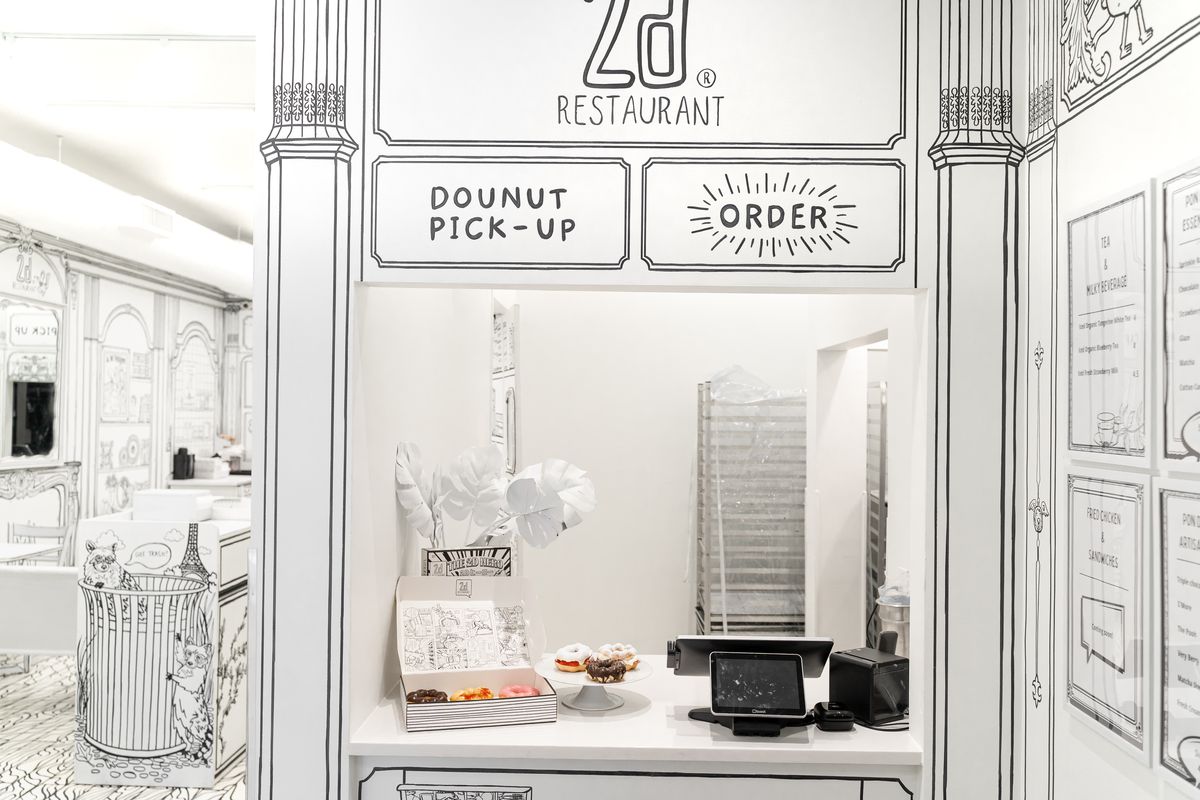 A black and white counter with a sign that reads “dounut pick-up.”