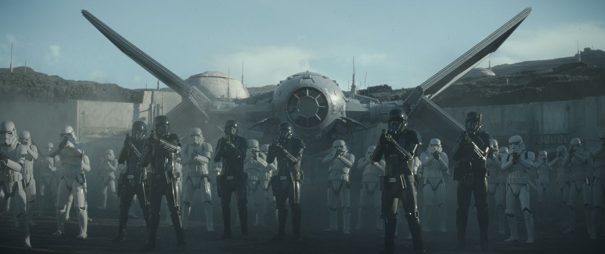 A squad of Death Troopers stands at the ready before Moff Gideon’s modified TIE fighter in the public square on Navarro. From The Mandalorian season 1, episode 7.