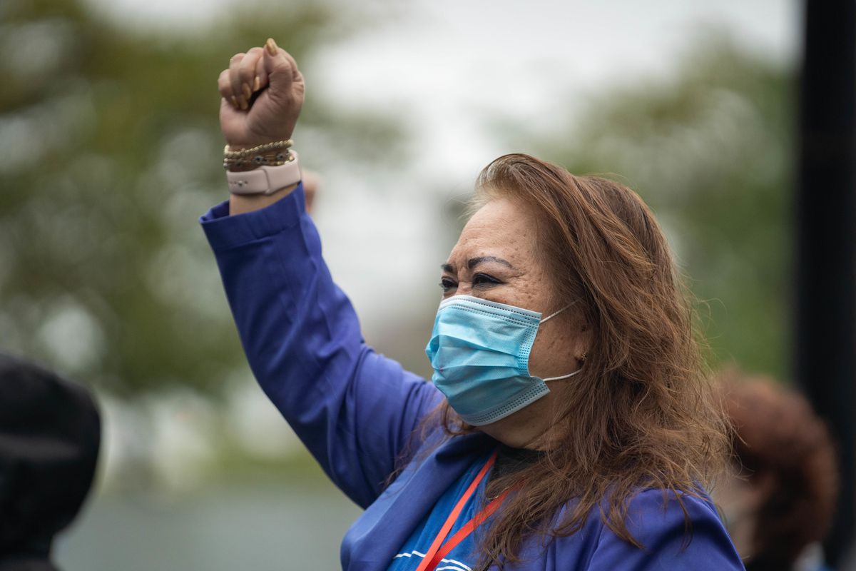 Josephine Daylo, a University of Illinois nurse who survived COVID-19, raises her fist outside the hospital on the first day of the strike Saturday.