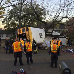 In this photo provided by the Chattanooga Fire Department via Chattanooga Times Free Press, Chattanooga Fire Department personnel work the scene of a fatal elementary school bus crash in Chattanooga, Tenn., Monday, Nov. 21, 2016. In a news conference Monday, Assistant Chief Tracy Arnold said there were multiple fatalities in the crash. 