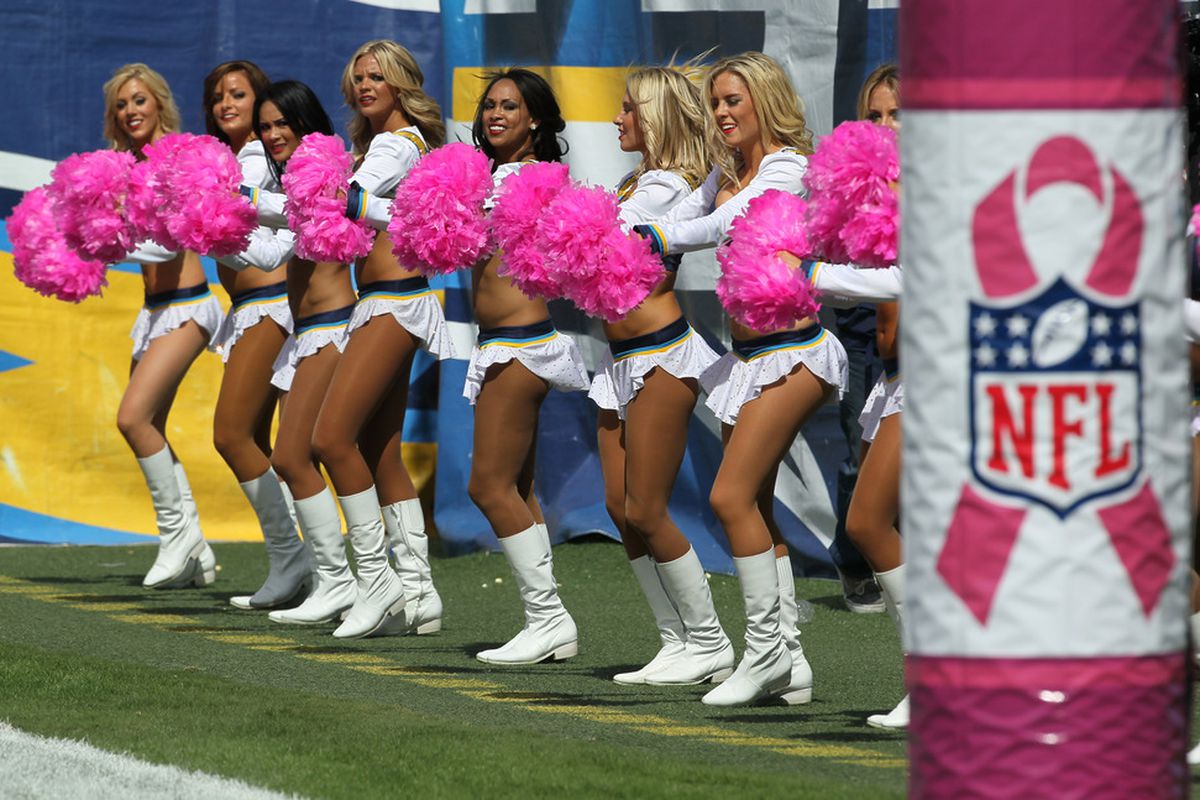 The Charger Girls cheerleader team performs with pink pompoms to acknowledge breast cancer awareness.  (Photo by Stephen Dunn/Getty Images)