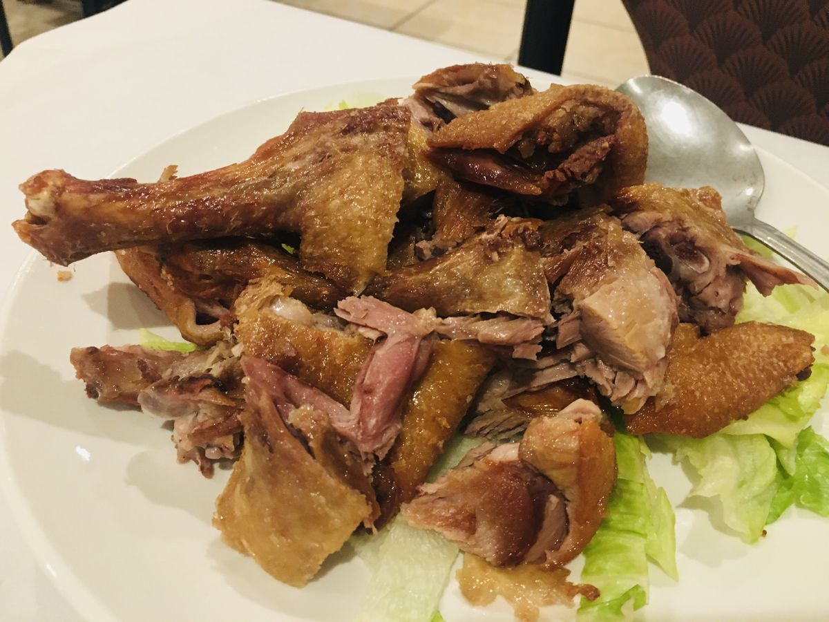 A pile of crispy fried duck on a white plate over chopped lettuce at LC’s Asian Kitchen. 