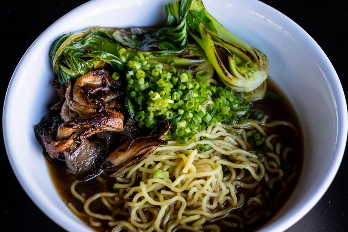 A bowl full of noodles, mushrooms, and vegetables. 