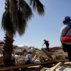 Members of a South Florida urban search and rescue team sift through a debris pile for survivors of Hurricane Michael in Mexico Beach, Fla., Sunday, Oct. 14, 2018. (AP Photo/David Goldman)