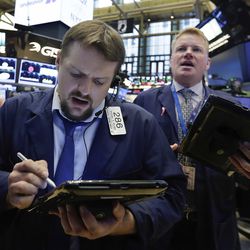 Traders Michael Milano, left, and John Bowers work on the floor of the New York Stock Exchange, Tuesday, Aug. 1, 2017. More solid earnings reports from U.S. companies are sending stocks higher in early trading on Wall Street. (AP Photo/Richard Drew)