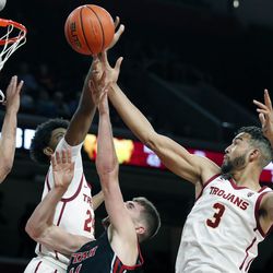 Southern California forward Joshua Morgan, left, and forward Isaiah Mobley, right, defend against a shot by Utah forward Riley Battin, center, during the first half of an NCAA college basketball game in Los Angeles, Wednesday, Dec. 1, 2021. 