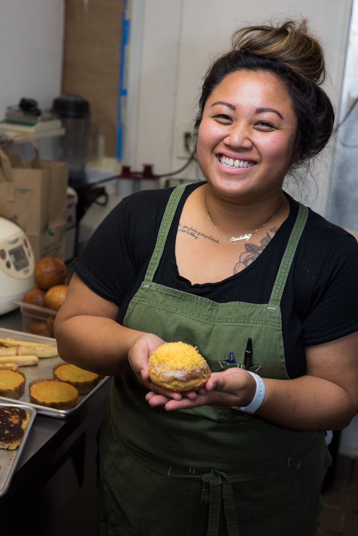 Ria Barbosa at her Downtown LA restaurant Petite Peso holding a Filipino pastry.