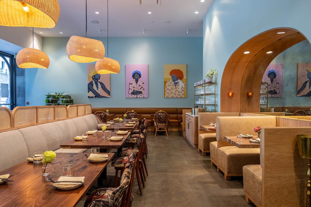 A light blue dining room with tan and dark brown seats inside a new restaurant Joyce in Los Angeles.