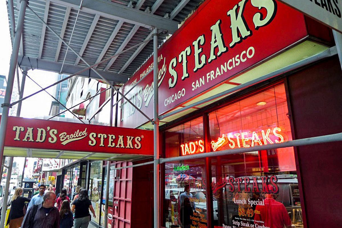 The exterior of Tad’s Steak, which has a red awning and an old-timey font.