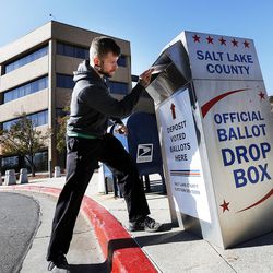Colin Cunningham places his ballot in a drop box at the Salt Lake County Government Center in Salt Lake City on Monday, Nov. 7, 2016.