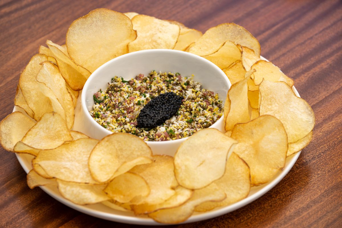 A bowl of chips and caviar dip.