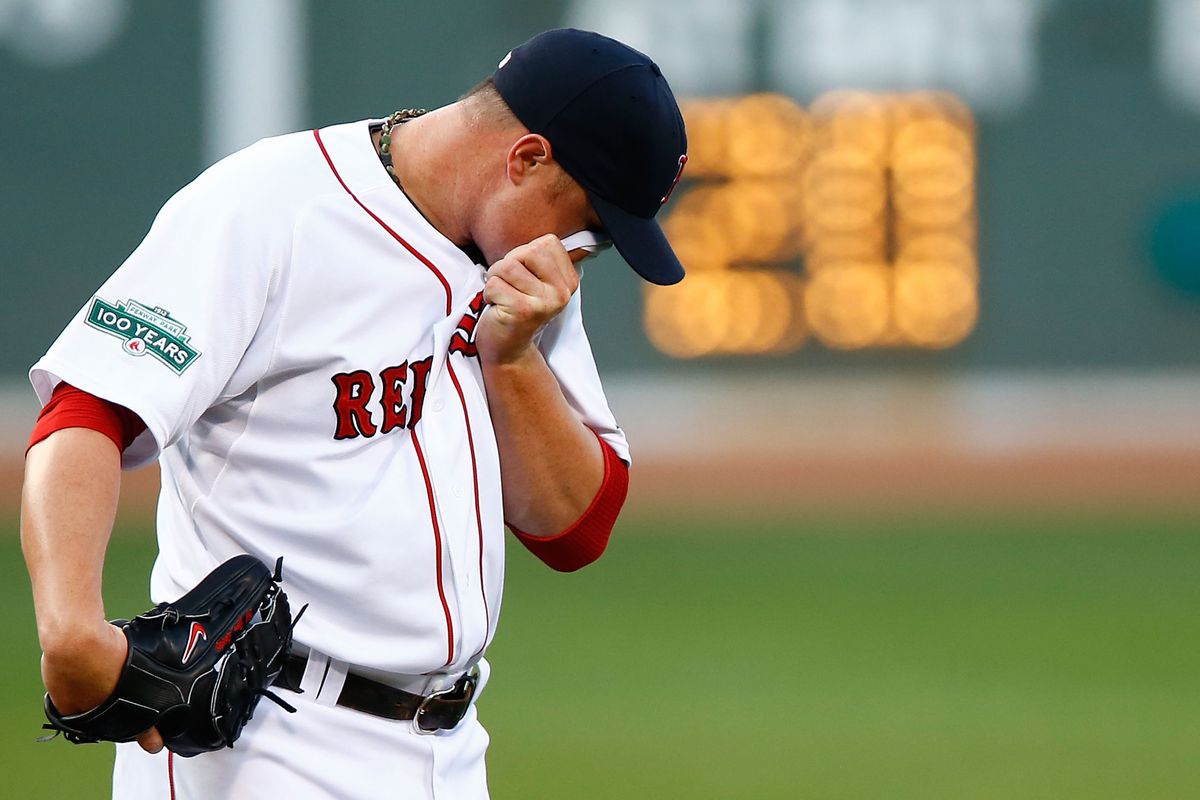BOSTON, MA: Jon Lester #31 of the Boston Red Sox wipes the sweat off of his face in between pitches against the Chicago White Sox during the game at Fenway Park in Boston, Massachusetts.  (Photo by Jared Wickerham/Getty Images)