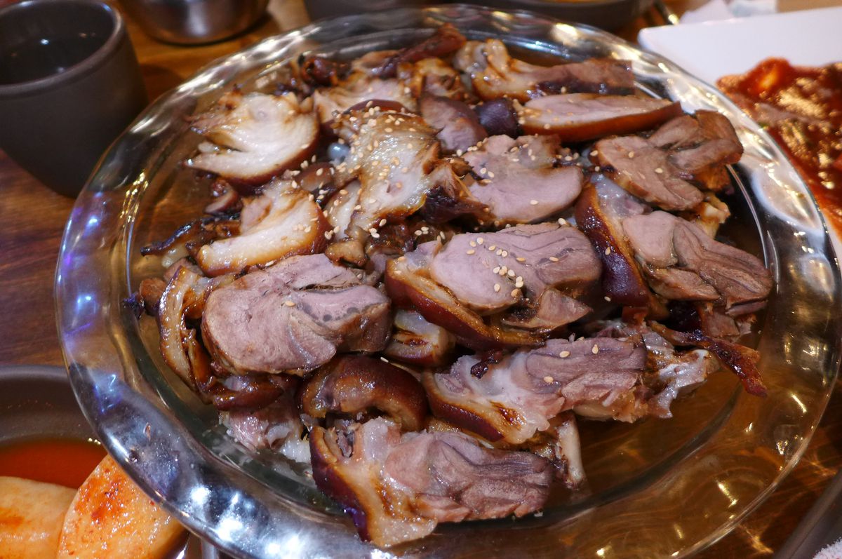 Slices of fatty pork on a round platter.