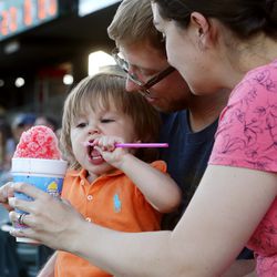 Jackson and Kelsey Richards help their daughter Lily eat a snow cone as they enjoy a Salt Lake Bees baseball game at Smith's Ballpark in Salt Lake City on Wednesday, June 5, 2019.