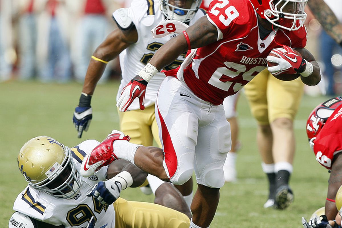 HOUSTON - SEPTEMBER 03:  Running back Michael Hayes #29 of the Houston Cougars breaks the tackle of  defensive end Owamagbe Odighizuwa #94 of UCLA at Robertson Stadium on September 3, 2011 in Houston, Texas.  (Photo by Bob Levey/Getty Images)