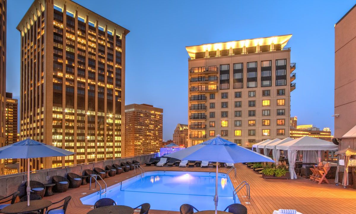 A hotel pool surrounded by hotel buildings.