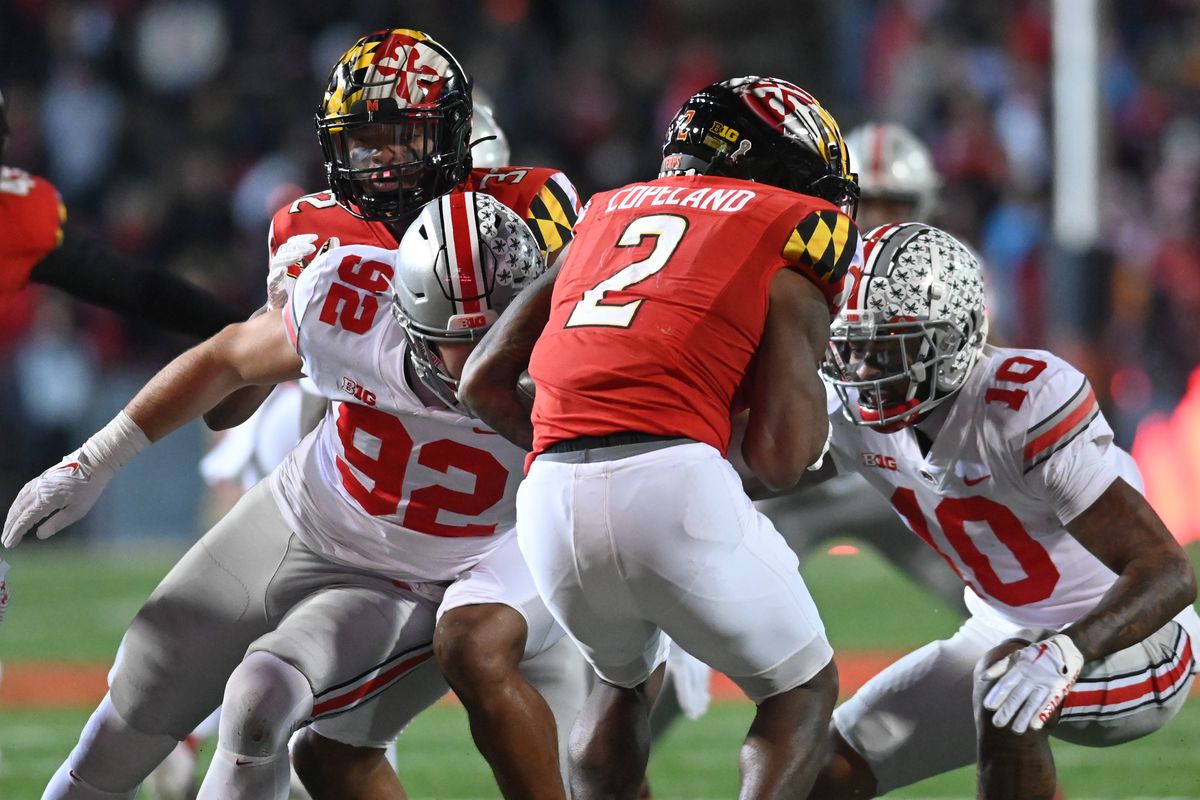 Nov 19, 2022; College Park, Maryland, USA; Ohio State Buckeyes defensive end Caden Curry (92) and Buckeyes cornerback Denzel Burke (10) tackle Maryland Terrapins wide receiver Jacob Copeland (2) during the second half at SECU Stadium.