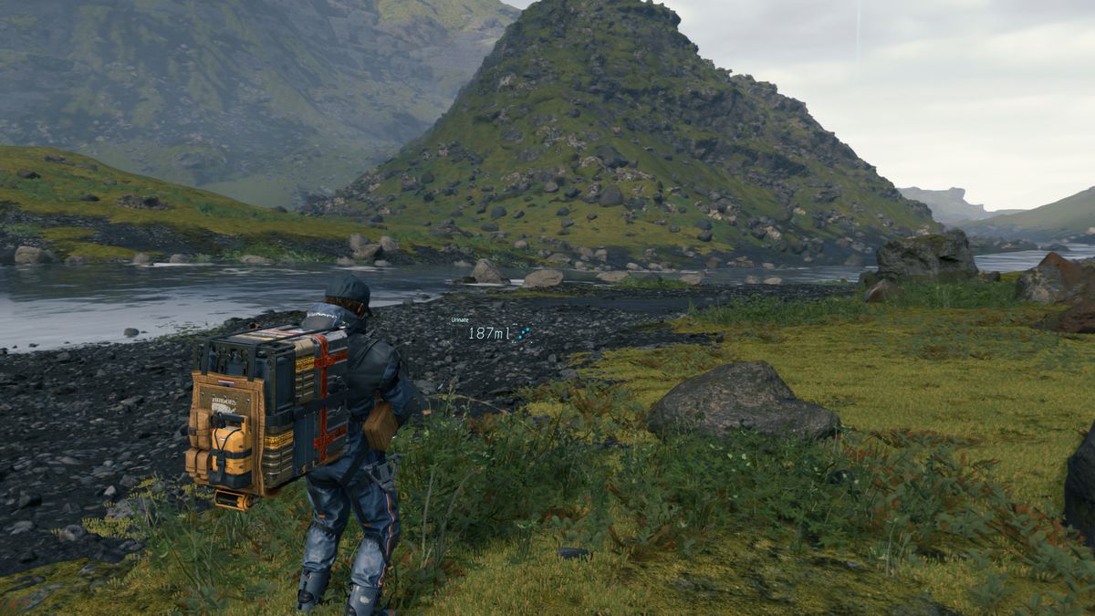Sam Bridges, a man wearing a large delivery backpack, urinating into some weeds near a river in Death Stranding