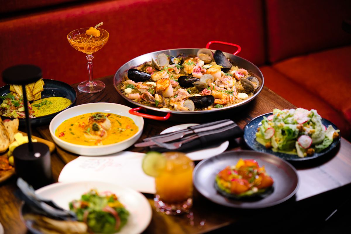 A table filled with ceviche, paella, tostadas, and other Latin American dishes at Alta Toro in Atlanta.