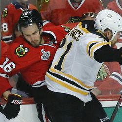 Chicago Blackhawks center Marcus Kruger (16) collides with Boston Bruins defenseman Andrew Ference (21) in the third period during Game 2 of the NHL hockey Stanley Cup Finals, Saturday, June 15, 2013, in Chicago. The Bruins won 2-1.