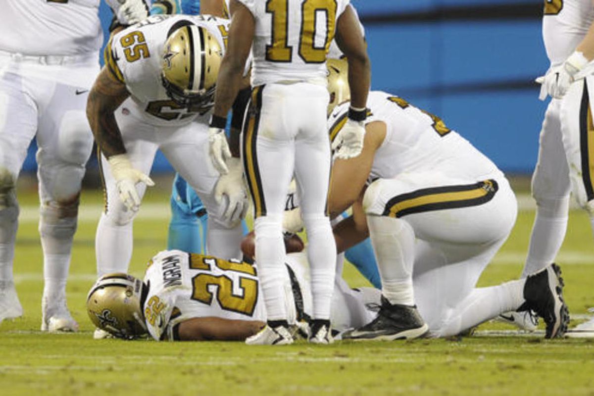 Teammates look to help New Orleans Saints' Mark Ingram (22) after he was injured in the second half of an NFL football game against the Carolina Panthers in Charlotte, N.C., Thursday, Nov. 17, 2016. (AP Photo/Mike McCarn)