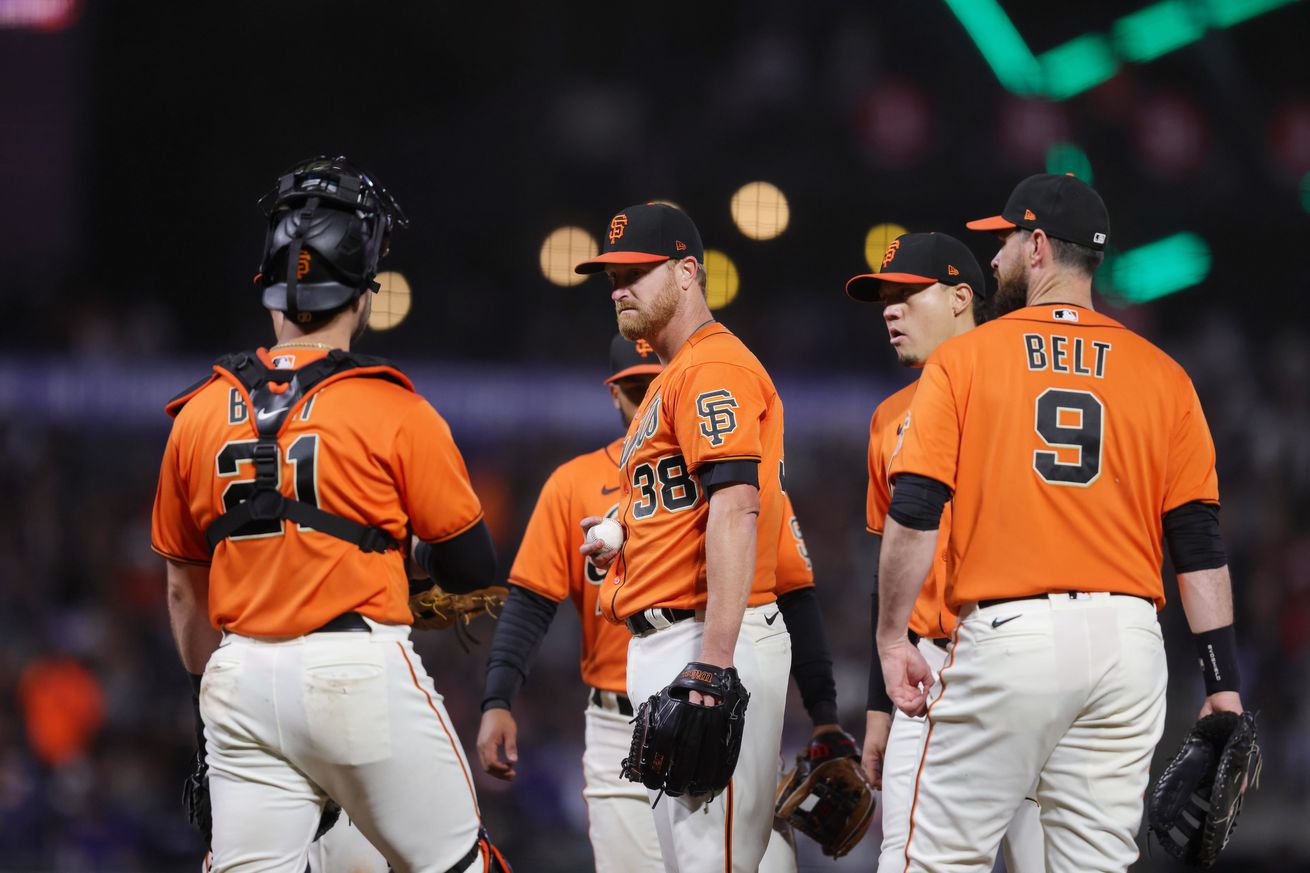 A gathering of San Francisco Giants at the mound during Friday night’s game.