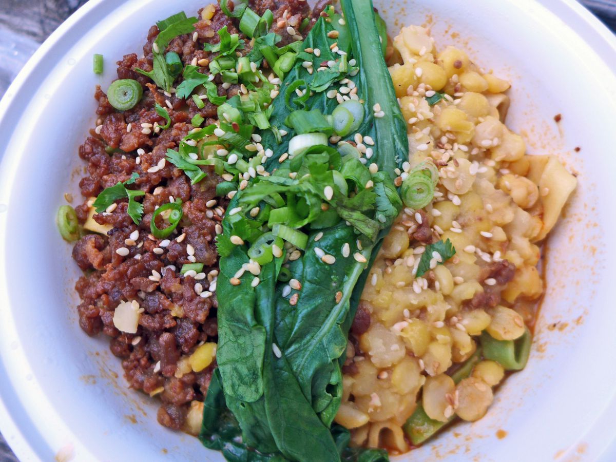Bands of yellow split peas, ground pork, and spinach lie across the top of the dish.