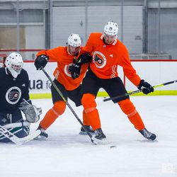 Joel Farabee (49) and Isaac Ratcliffe (76) battle for the puck in front of the net during drills for Flyers Rookie Camp. 