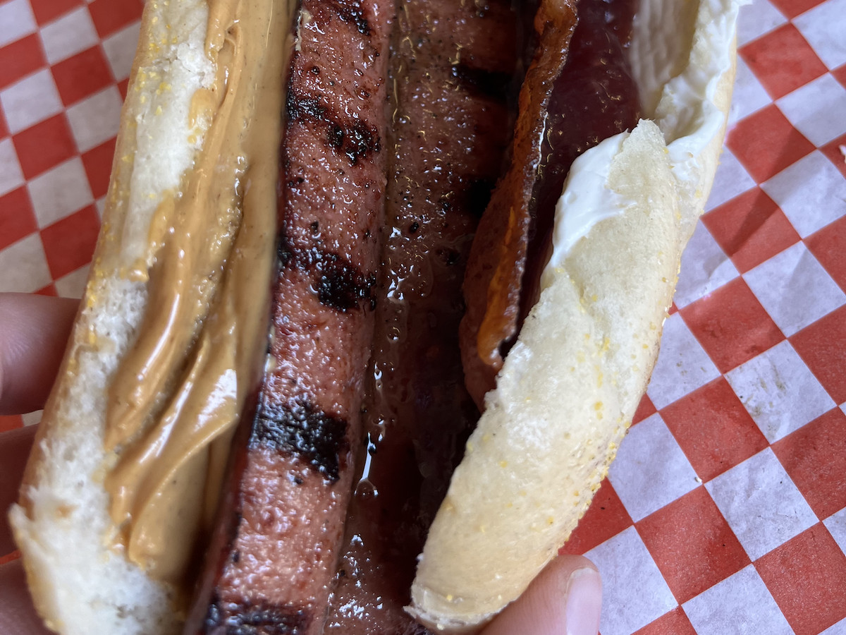 A hot dog with peanut butter, cream cheese, jelly, and bacon.