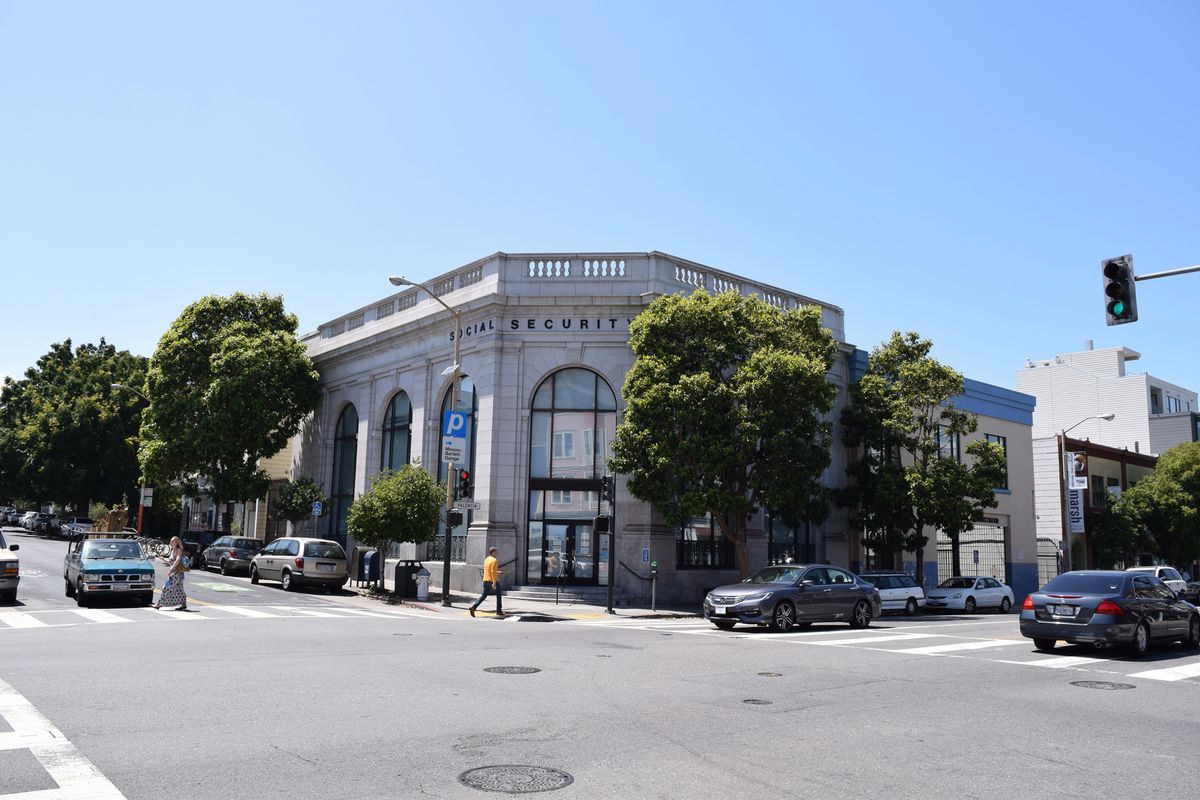 The exterior of the Hibernia Bank on Valencia Street, a stone and concrete neoclassical building with arched entrances.