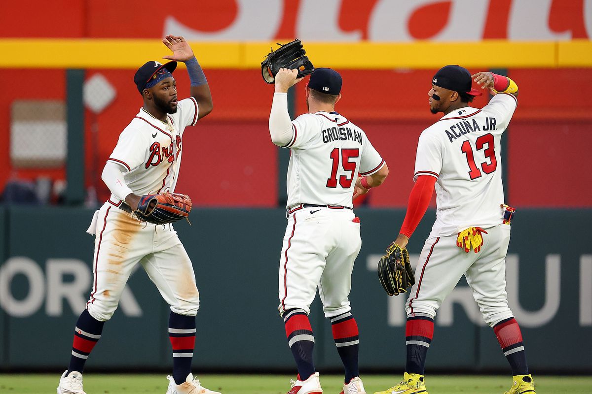 Michael Harris II, Robbie Grossman, and Ronald Acuna Jr. of the Atlanta Braves react after their 3-2 win over the New York Mets at Truist Park on August 18, 2022 in Atlanta, Georgia.