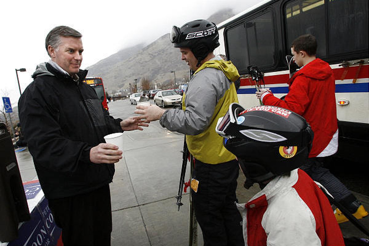 Salt Lake County Mayor Peter Corroon, left, hands a cup of hot chocolate to Rick Page and his son, Wyatt, as they get off a bus Monday at the Park and Ride lot at 6200 S. Wasatch Blvd. Corroon was on hand to thank skiers and snowboarders for using mass tr