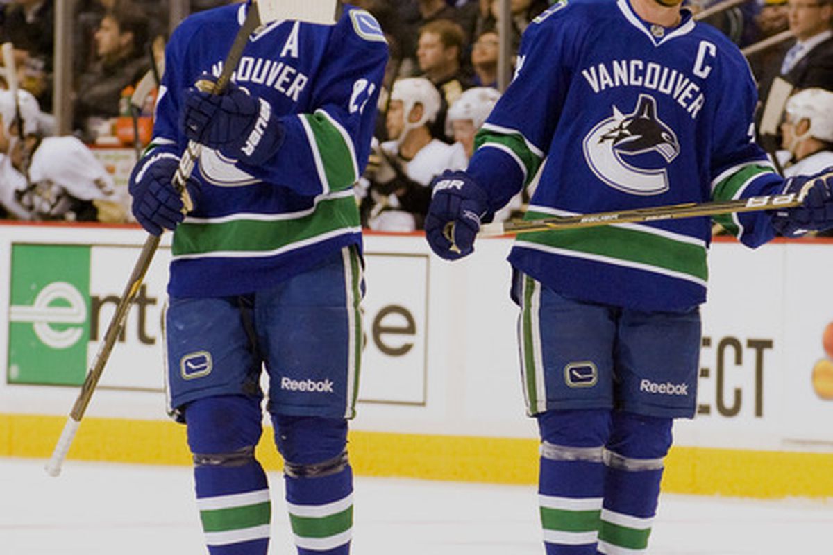 Daniel Sedin (22) and Henrik Sedin (33) of the Vancouver Canucks stand on the ice against the PIttsburgh Penguins during the first period on October 6, 2011 at Rogers Arena in Vancouver, B.C.  (Photo by Marissa Baecker/Getty Images)