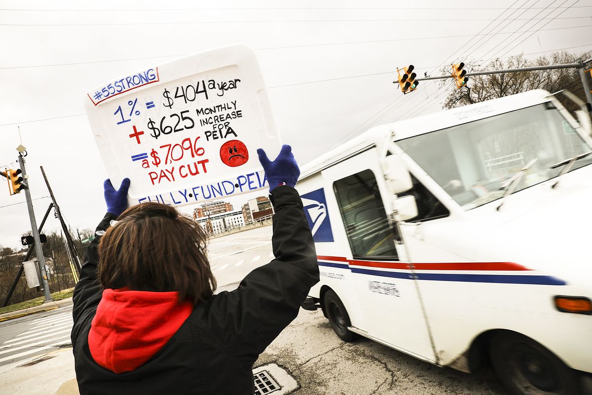 West Virginia teachers, students and supporters hold signs on a Morgantown street as they continue their strike on March 2, 2018 in Morgantown, West Virginia.