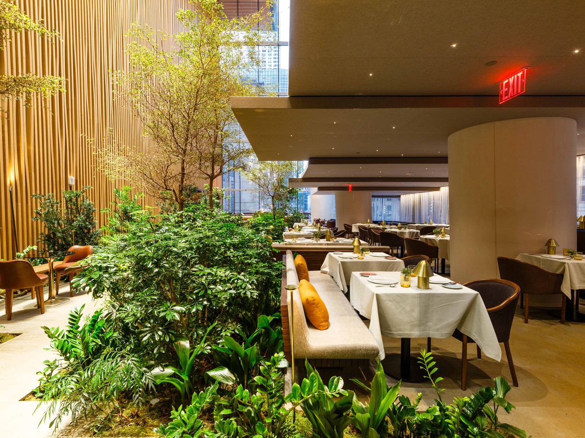 Greenery and olive trees line the left side of the dining room at Le Pavillon.