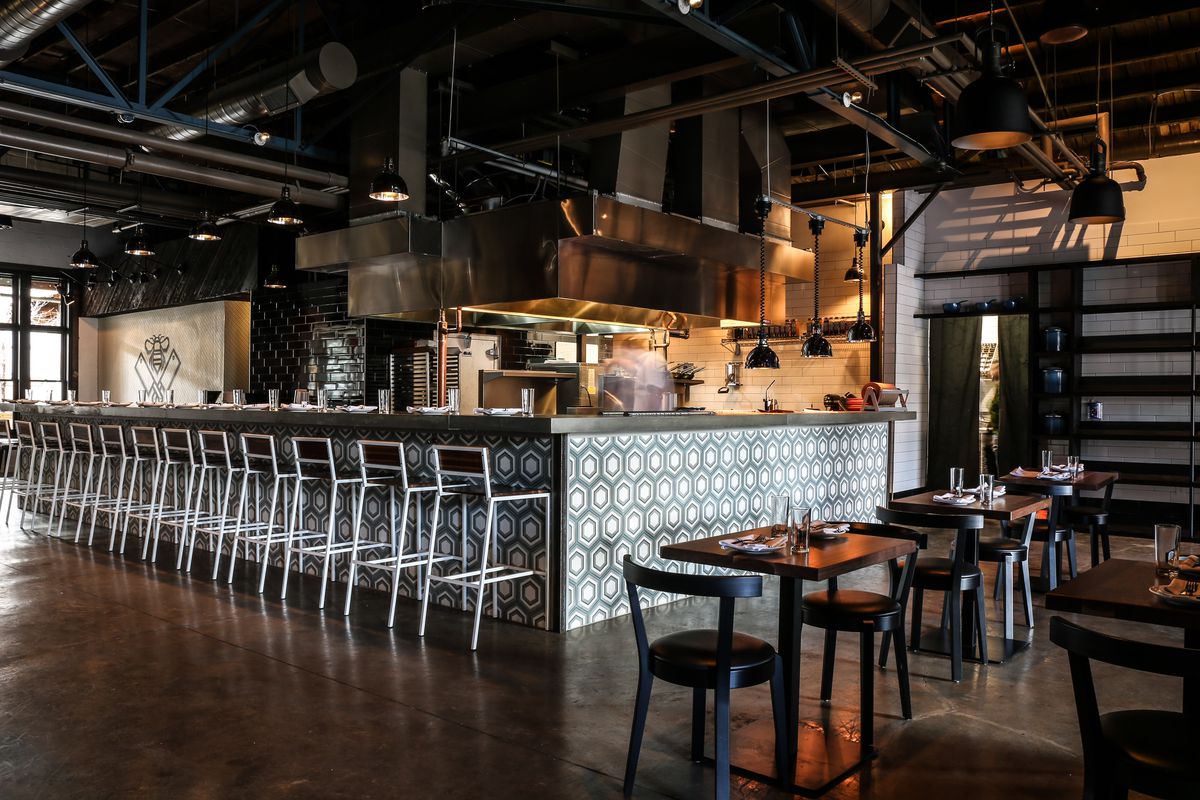 A couple of low-top tables and the bar with stools at Butcher &amp; Bee