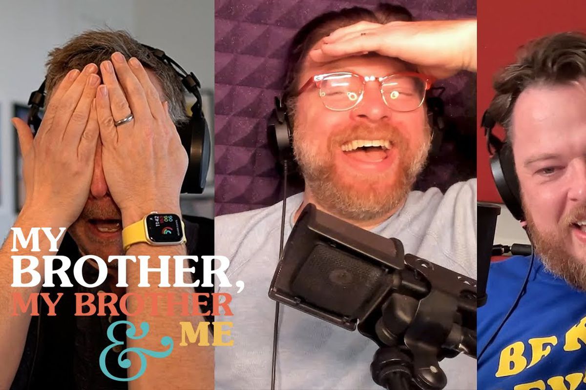 A screenshot of a three-way split screen showing, left to right, Griffin, Travis, and Justin McElroy. Griffin is covering his face with his hands, Travis has a hand to his forehead, laughing, and Justin has his mouth open. In the lower left corner is the logo for My Brother, My Brother and Me.