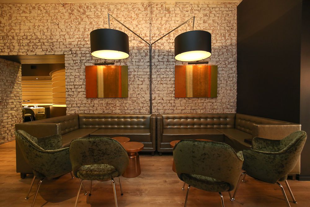 A photo of a lounge space with four chairs and two over hanging lights at RIoja